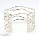Zilveren (925) brede (4,5cm) armband bestaande uit ovalen draden die speels patroon volgen.