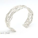 Zilveren armband bolletjes en ronde draden die speels patroon volgen.