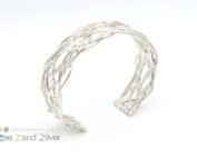 Zilveren armband bolletjes en ronde draden die speels patroon volgen.