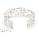 Zilveren armband bolletjes en ronde draden die speels patroon volgen.