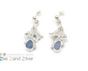 Zilveren (925) oorbellen bestaande uit draden waar tussen natuurstenen opaal en topaas (licht blauw) gezet zijn.