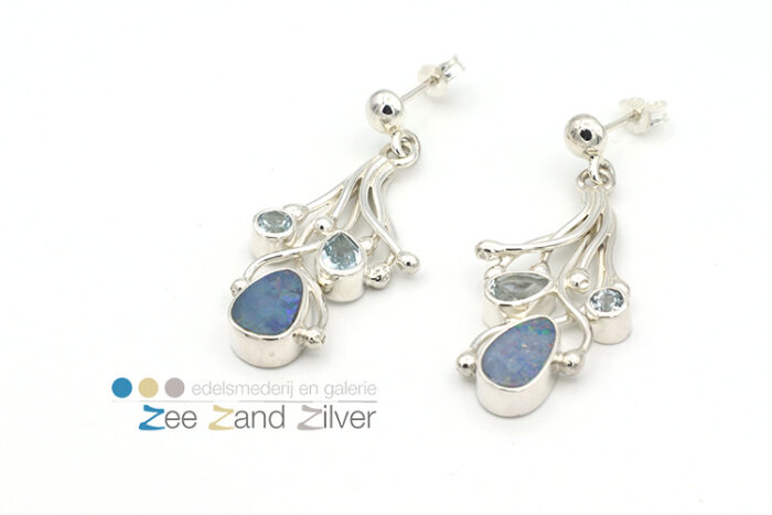 Zilveren (925) oorbellen bestaande uit draden waar tussen natuurstenen opaal en topaas (licht blauw) gezet zijn.